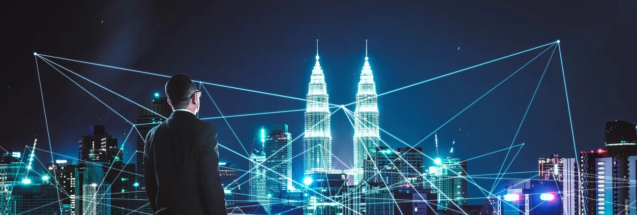 Kuala Lumpur skyline at night with a connected network overlay